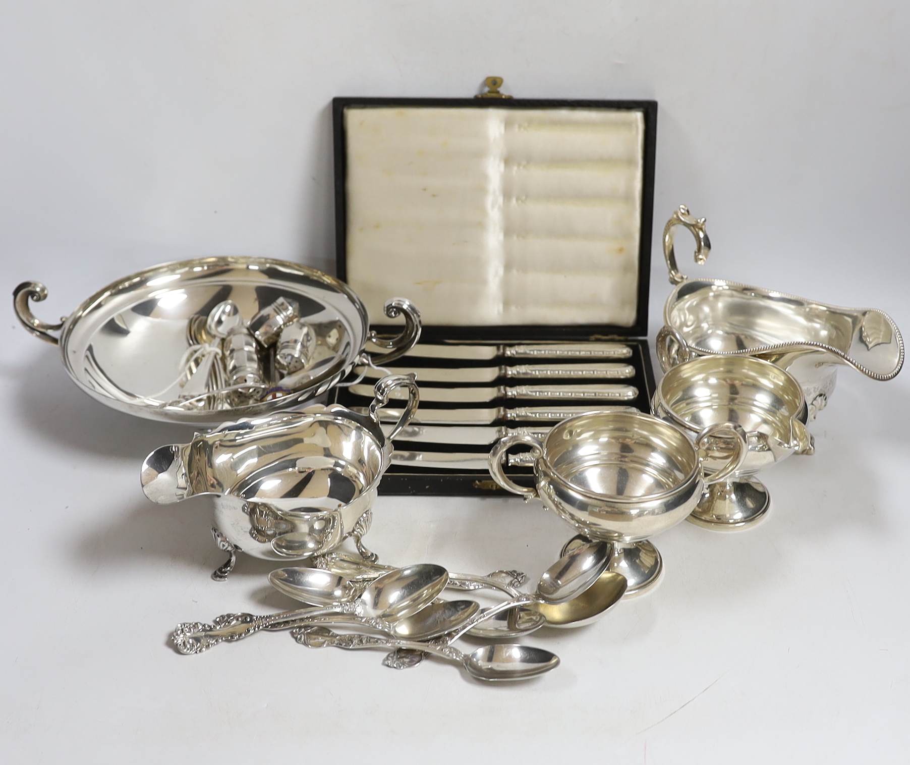 A small collection of silver including a sauceboat, two handled shallow bowl, five teaspoons and a commemorative spoon, together with a sterling cream jug and sugar bowl, sterling flatware and set of four pepperettes, to